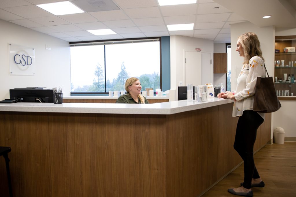 Patient at front desk of Golden State Dermatology