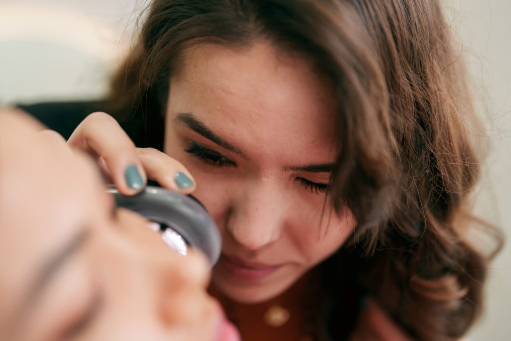 Dermatologist examining a patient's skin with a dermatoscope