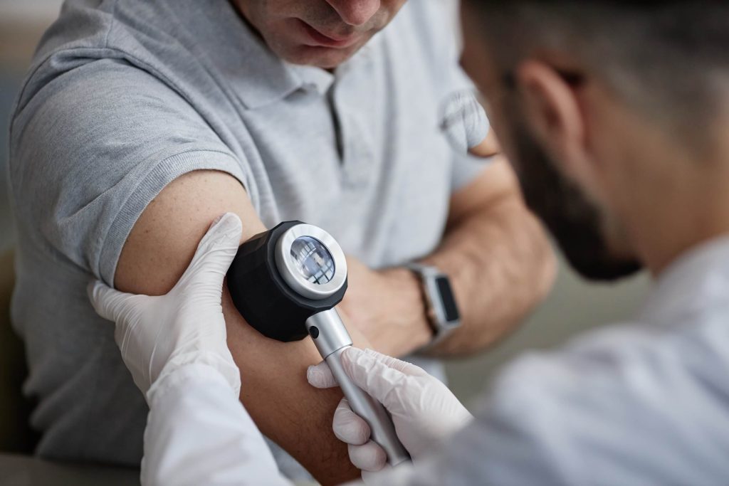 Middle-aged man receiving a full skin examination from a dermatologist.