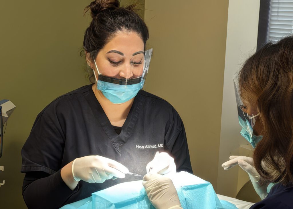 A dermatologic surgeon performing a Mohs procedure with an assistant